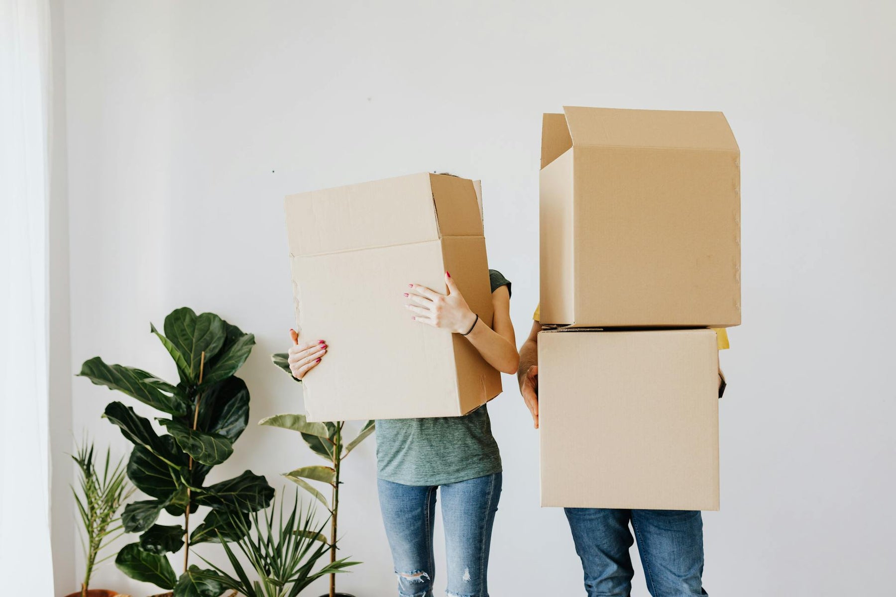 A couple carry boxes as they’re moving house.